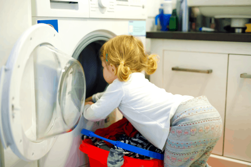 toddler girl doing laundry