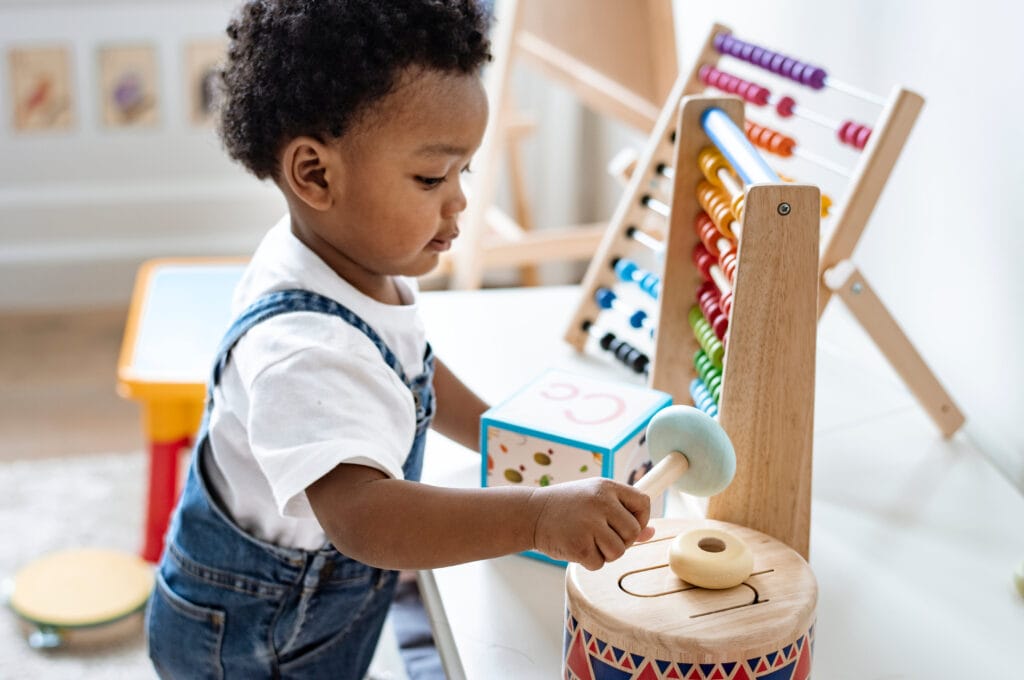 Toddler with a wooden drum