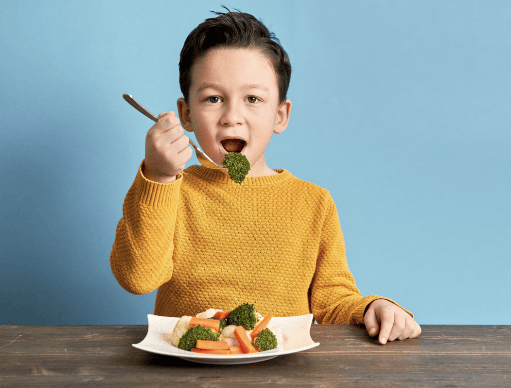 child eating with utensils
