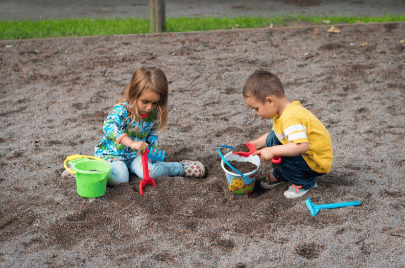 children parallel play in sandbox