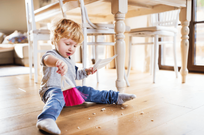 Child Learning with a dust pan and brush