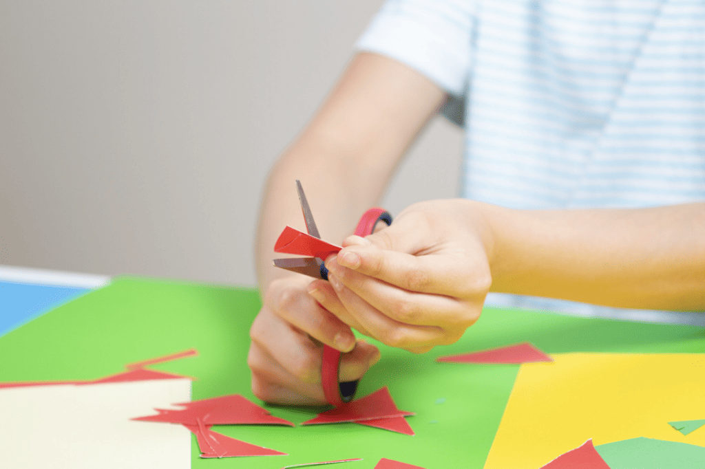 a child cutting paper with scissors