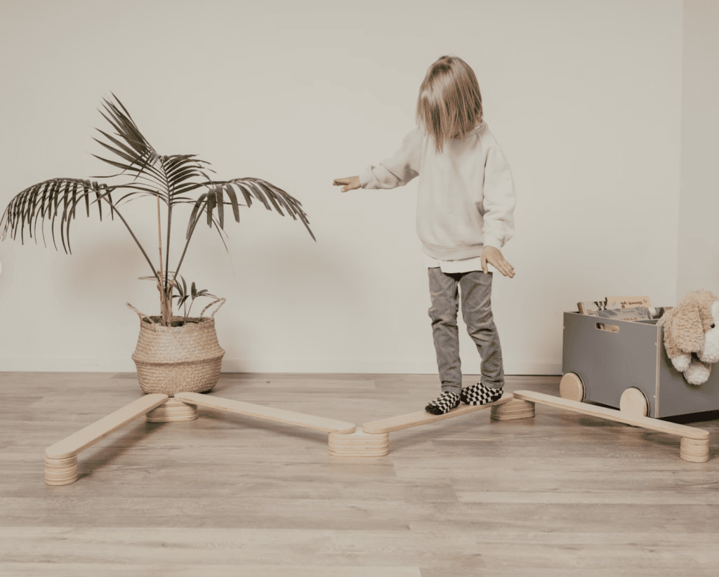 Kid playing on a wooden balance beam